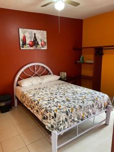 1 cama en un dormitorio con paredes de color naranja en Sensity Home Casa confortable en Fracc Privado Céntrica, en Tehuacán