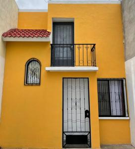 un edificio amarillo con barrotes en las ventanas en Sensity Home Casa confortable en Fracc Privado Céntrica, en Tehuacán