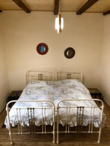 a bedroom with a white bed with two chairs at Elizabeth's Rooms in Kutaisi