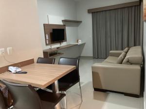 a living room with a wooden table and a couch at Apartamento Luxo Marina Flat & Náutica in Caldas Novas