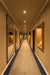 un couloir d'un hôtel avec un couloir recouvert de moquette dans l'établissement Parkhotel Hohenfeld Münster, à Münster