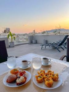 einen Tisch mit zwei Teller Essen und zwei Tassen Kaffee in der Unterkunft My Home in Greece in Athen