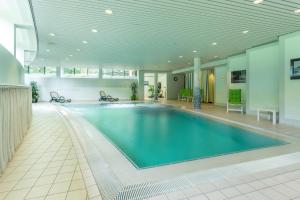 a large swimming pool in a large building at Parkhotel Hohenfeld Münster in Münster