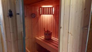 a small wooden sauna with a bucket in it at Feriendorf Südstrand Haus 23 in Pelzerhaken