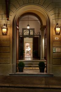 un ingresso a un edificio con due piante in vaso di Casa Howard Firenze - Residenza d'Epoca a Firenze