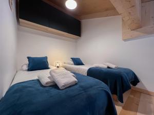 twee bedden in een kamer met blauw en wit bij Perle de savoie - Apt C706 - BO Immobilier in Châtel