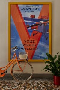 una bicicletta parcheggiata accanto a un grande poster su un muro di Casa Howard Firenze - Residenza d'Epoca a Firenze