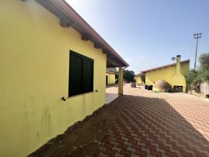 un edificio amarillo con una ventana en el lateral en Residence Sulcis 2, en Masainas