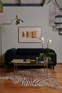 un soggiorno con divano nero e tappeto zebrato di Casa Howard Firenze - Residenza d'Epoca a Firenze
