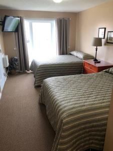 Cette chambre comprend deux lits et une télévision. dans l'établissement Paradise Canyon Golf Resort - Luxury Condo M405, à Lethbridge