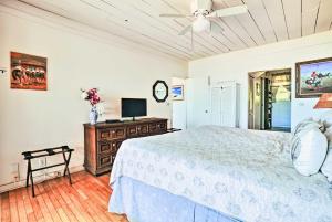 a bedroom with a bed and a ceiling fan at Tropical Paniolo Hale Townhome, Walk to Beach in Maunaloa
