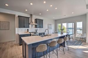 a kitchen with a large island with bar stools at Picturesque Moses Lake House with Boating Dock in Moses Lake