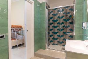 uma casa de banho com um chuveiro com azulejos verdes em Affittacamere Sopra le mura em Nápoles