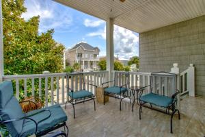 een veranda met stoelen en tafels op een balkon bij Sarah Sue in Carolina Beach