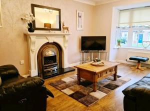 a living room with a fireplace and a coffee table at Spacious 4 bed home in a quiet cul-de-sac in Coundon