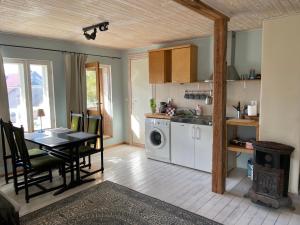 a kitchen and dining room with a table and a stove at Väike-Liiva Villa in Haapsalu