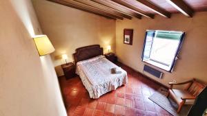 um quarto com uma cama e uma janela em Casa Tinoco Casa Rural Categoria Superior em Fuenteheridos
