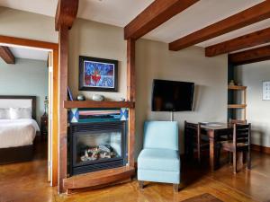 a room with a fireplace and a bed and a chair at Beautiful Condo In A Great Location, Oceanfront Complex - Oe in Ucluelet