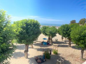 een uitzicht over een strand met bomen en een speeltuin bij Appt FOURAS Centre Ville 50m de la Mer in Fouras