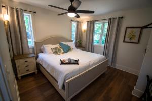 a bedroom with a bed with a fan and windows at Mission Springs Resort in Ashland