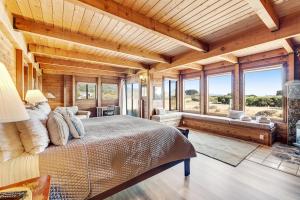 a bedroom with a large bed in a room with windows at Shell Beach in Sea Ranch