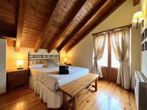 een slaapkamer met een groot bed en een houten plafond bij El Dúplex de Espot in Espot