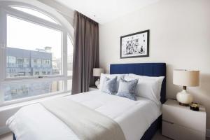 a bedroom with a large bed with a large window at Buckingham Palace Residences by Q Apartments in London