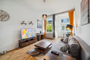 a living room with a couch and a tv at Infinity Stay: Bis zu 4 Personen Zentrum Wassernah Netflix in Wilhelmshaven