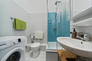 a bathroom with a washing machine and a sink at Infinity Stay: Bis zu 4 Personen Zentrum Wassernah Netflix in Wilhelmshaven