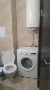 uma casa de banho com uma máquina de lavar roupa e um WC em Studio Sarafovo em Burgas