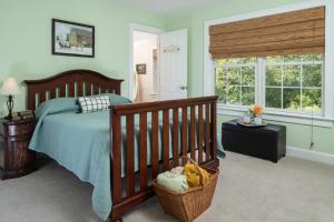 ein Schlafzimmer mit einem Bett mit einem Kinderbett und einem Fenster in der Unterkunft Apple Pony Inn in Boalsburg