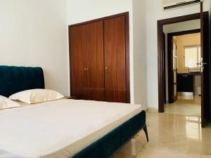 a bedroom with a bed and a wooden cabinet at The Perfect Flat, Lac 2, Tunis in Tunis +9 photos