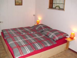 łóżko z czerwonym i szarym kocem i dwoma lampami w obiekcie Apartment 2 Langelsheim Harz w mieście Langelsheim