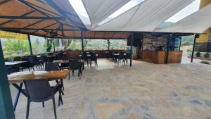 ein Esszimmer mit Tischen, Stühlen und Fenstern in der Unterkunft Olive Tree Apart Hotel in Muğla