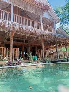 a house with a swimming pool in front of it at villa gilimakyah in Gili Air
