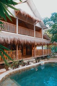 a resort with a swimming pool in front of a house at villa gilimakyah in Gili Air