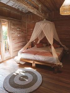 a bedroom with a bed with a mosquito net at villa gilimakyah in Gili Air