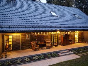 ein Haus mit einer Terrasse mit Stühlen und Beleuchtung in der Unterkunft Bergervilla Boutique Guest House & SPA in Mežmuiža