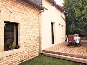 eine Terrasse mit einem Tisch und Stühlen auf einer Holzterrasse in der Unterkunft Le Penty de Nalzu in Saint-Yvy