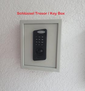 un mando a distancia en un marco de imagen en una pared en Hotel Apartment am Arbach, en Eningen unter Achalm