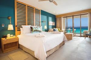 a bedroom with a large bed with a view of the ocean at Dreams Natura Resort & Spa - All Inclusive in Puerto Morelos