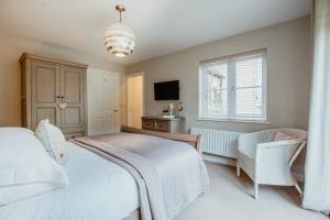 1 dormitorio con 1 cama, TV y ventana en Lavender Lodge Bourton, en Bourton on the Water