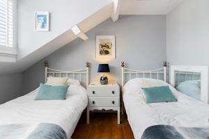 two twin beds in a room with a attic at Hope Cottage, Brixham in Brixham