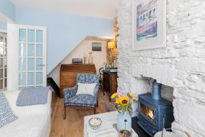 a living room with a stone wall with a stove at Hope Cottage, Brixham in Brixham