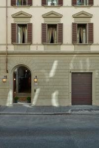 フィレンツェにあるCasa Howard Firenze - Residenza d'Epocaの二つのガレージドアが横に建つ建物