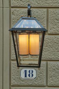 a light on the side of a building with a sign at Casa Howard Firenze - Residenza d'Epoca in Florence