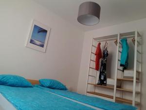 Schlafzimmer mit einem Bett mit blauer Bettwäsche und einem Schrank in der Unterkunft Ana's in Stari Grad