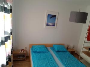 um quarto com duas almofadas azuis numa cama em Ana's em Stari Grad