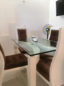 une table en verre avec deux chaises et une lampe sur celle-ci dans l'établissement CASA VERDE - APARAMENTOS BUCARAMANGa, à Bucaramanga
