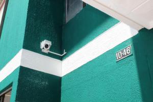 - un bâtiment vert et blanc avec caméra dans l'établissement CASA VERDE - APARAMENTOS BUCARAMANGa, à Bucaramanga